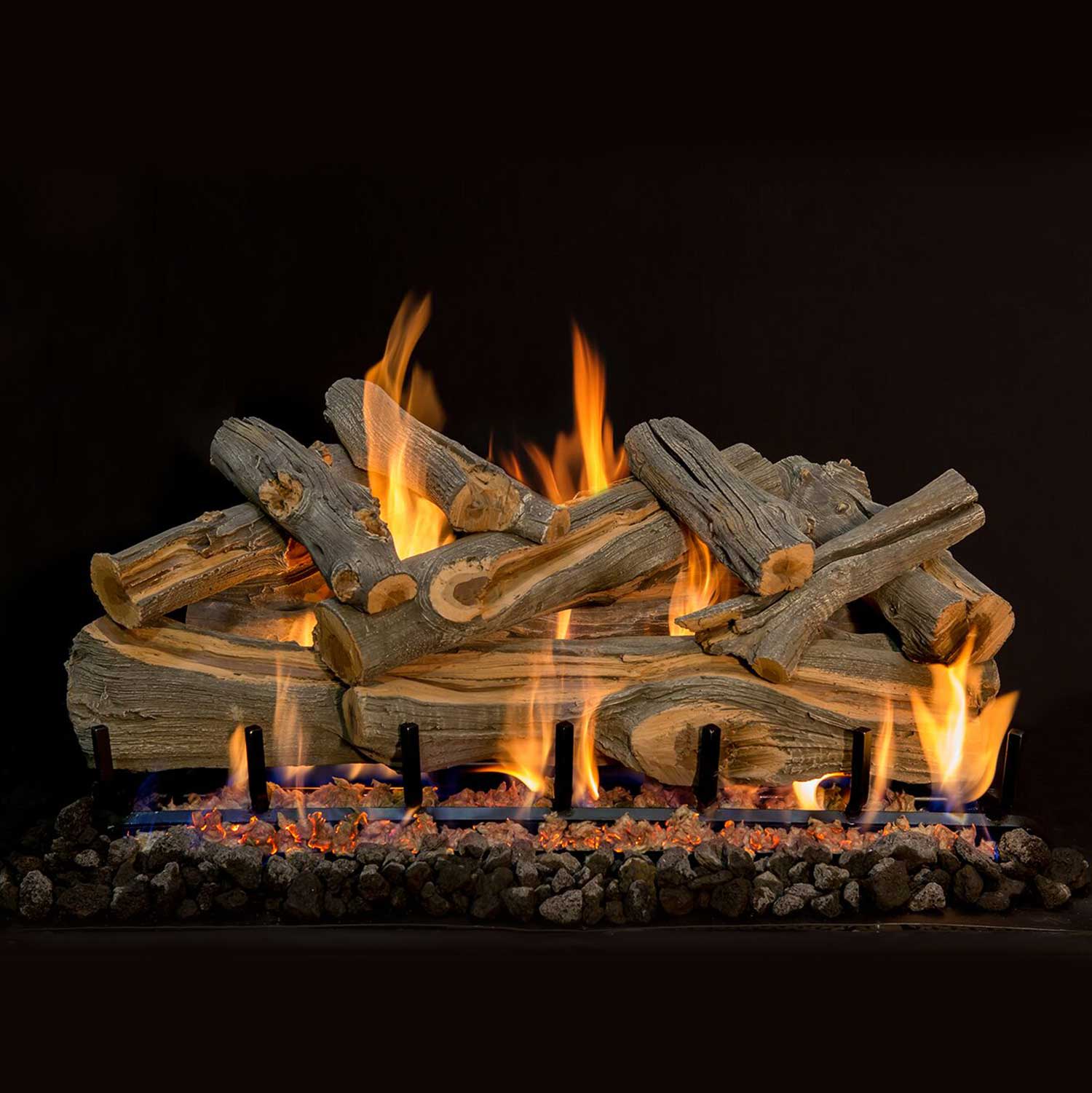 Double-sided gas log set with charred gray logs, orange flames, and lava rock base