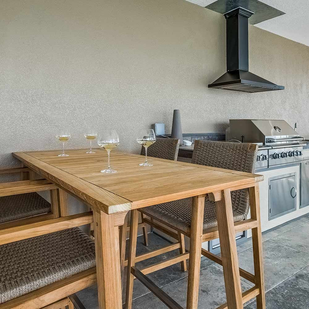 Teak counter-height dining table with woven chairs, light wood legs and tan seat cushions