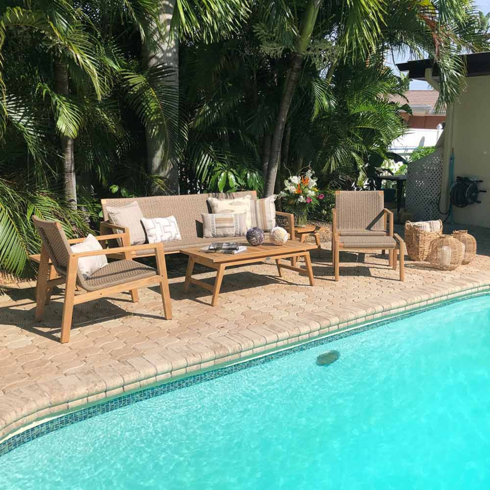 Outdoor seating set with charcoal cushions, two chairs, and teak coffee table