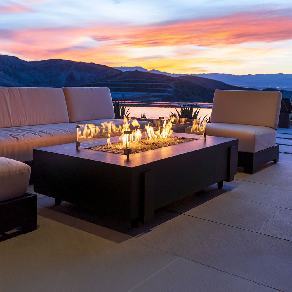 Rectangular GFRC gas fire table with black base and visible flames in the burner
