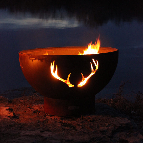 Gas fire pit with antler cutout and steady flames on dark steel bowl