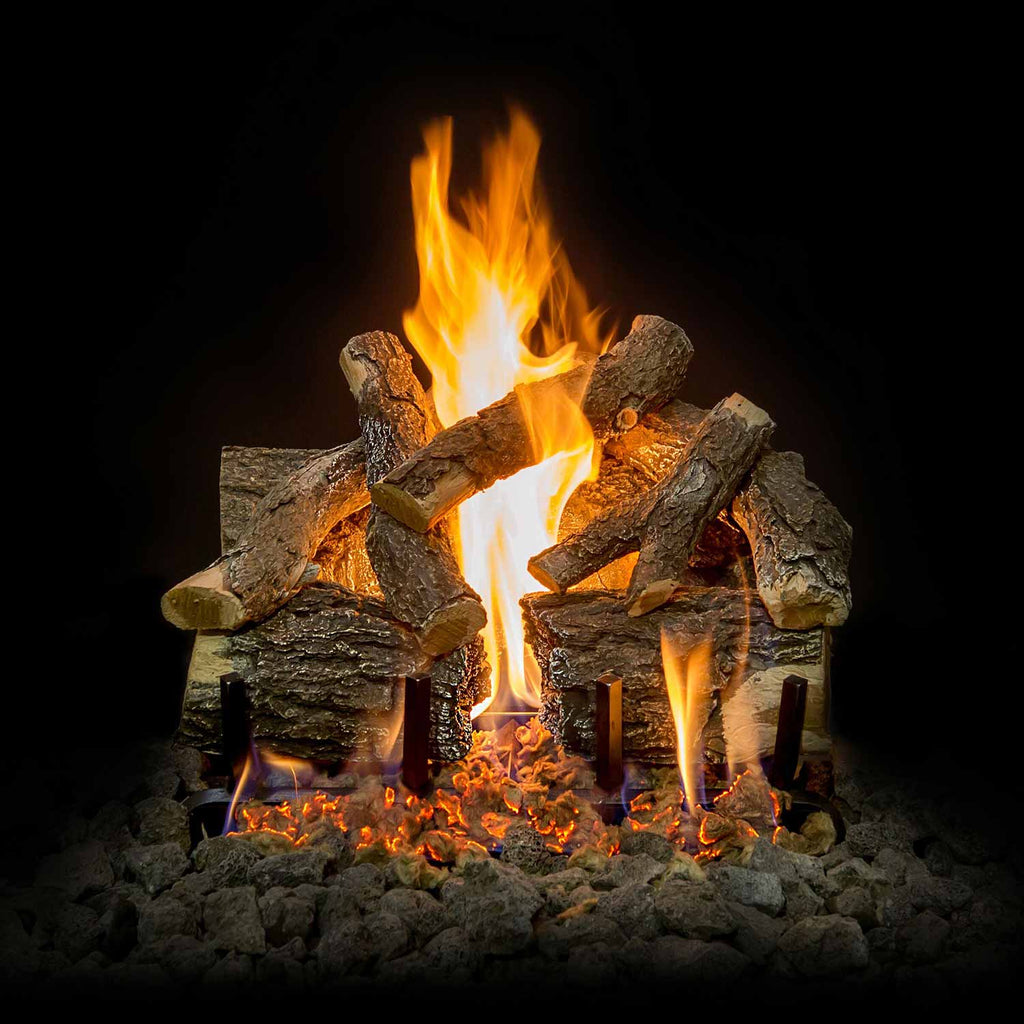 Charred gas log set with central flames rising from stacked logs