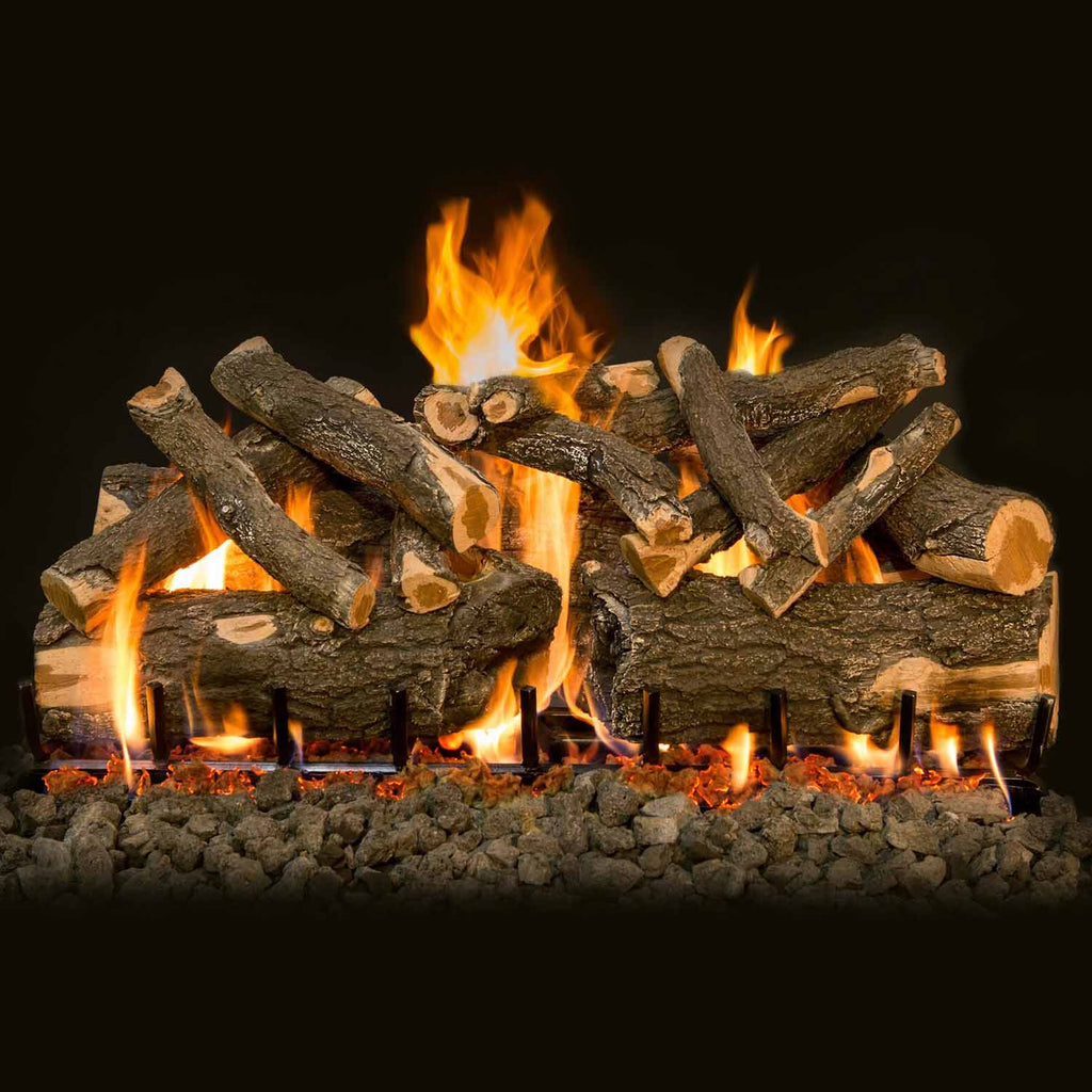 Burning gas logs with glowing flames and ember bed stones in front