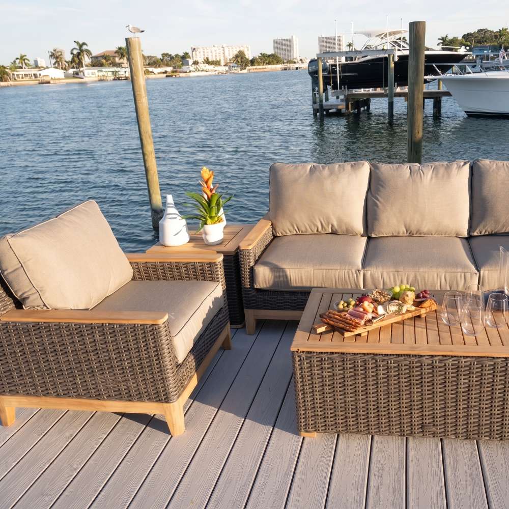 Outdoor seating set with dark wicker sofa, armchair, and rectangular coffee table with wood top