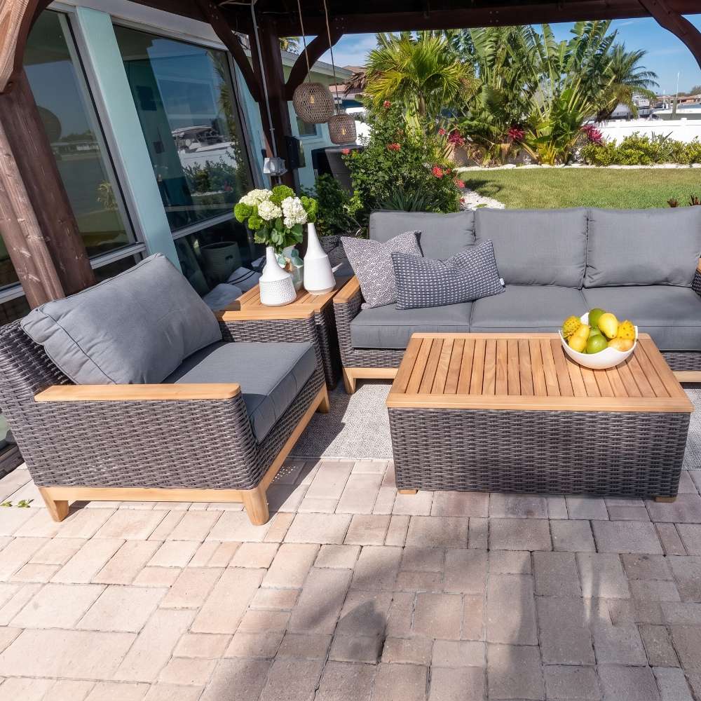 Outdoor seating set with dark wicker sofa, armchairs, and rectangular coffee table with wood top