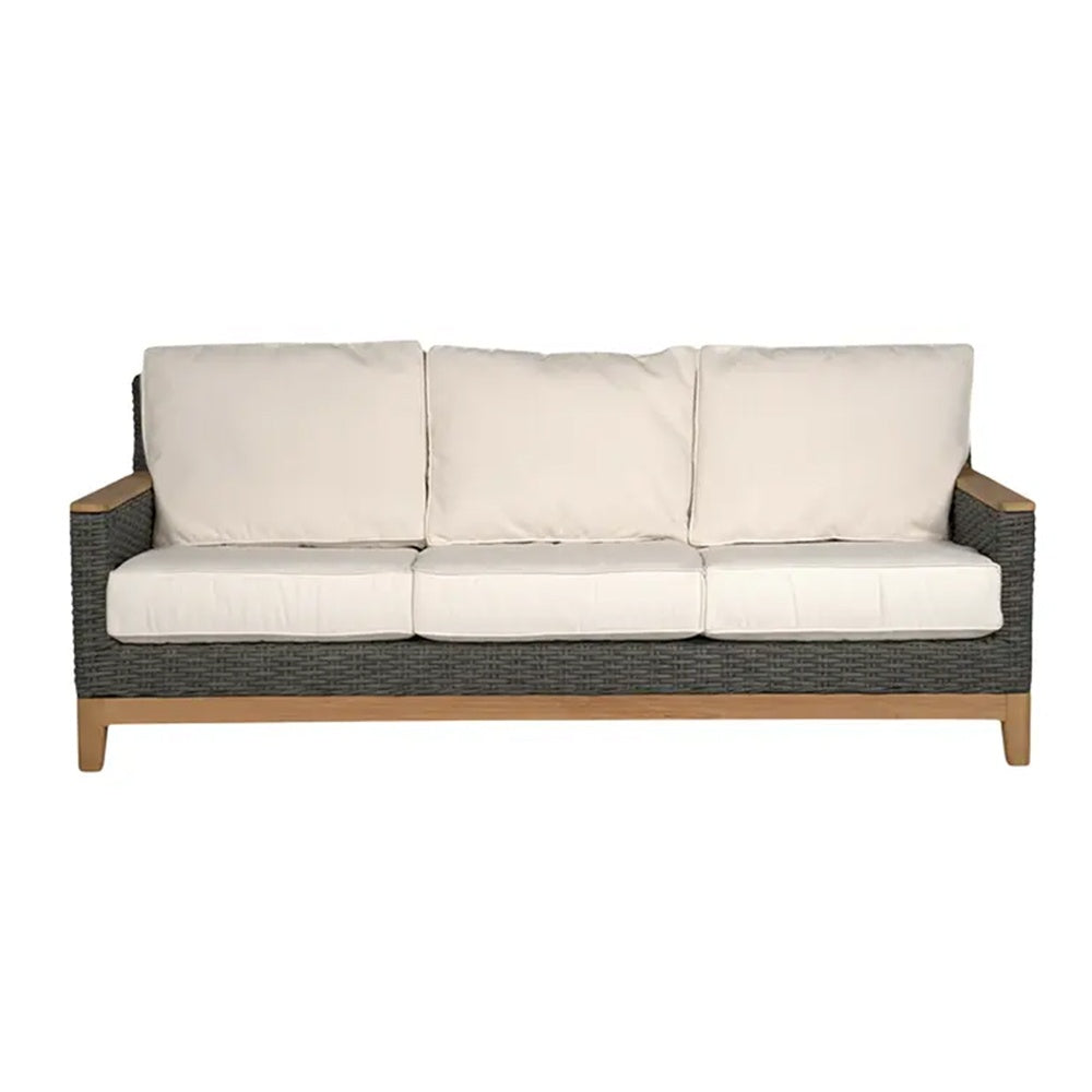 Charcoal wicker sofa with three white seat cushions and padded back cushions
