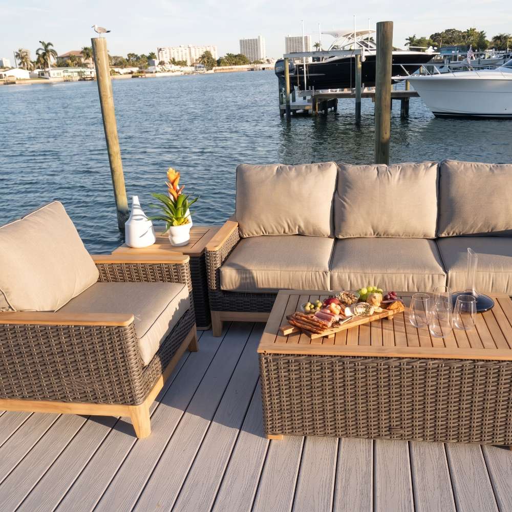 Woven wicker sofa with tan cushions and three seat back pillows