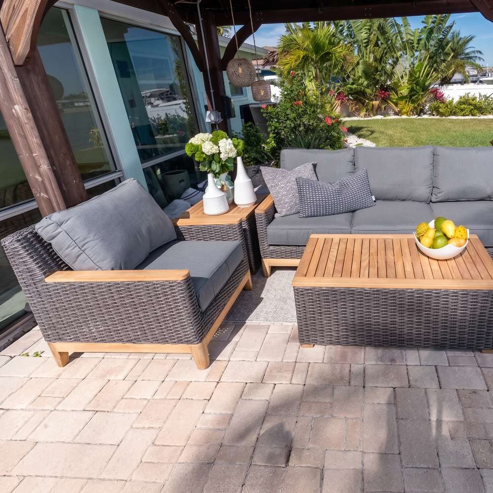 Outdoor woven lounge chair with charcoal arms and light gray seat cushions