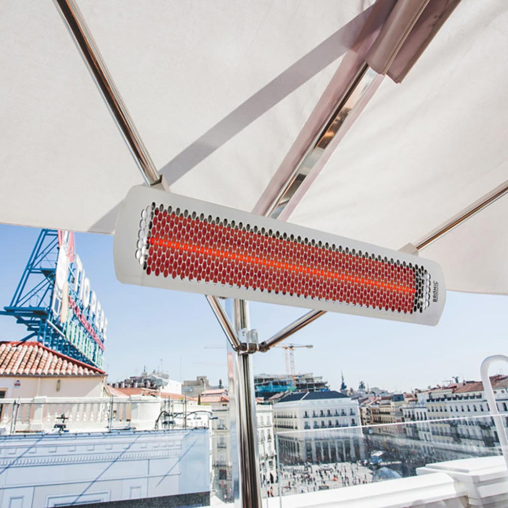 Hanging electric heater with white housing and red heating element, mounted under an awning