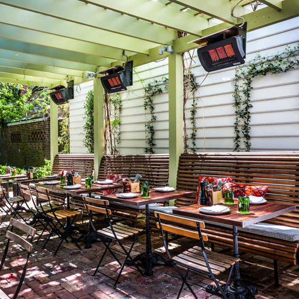 Outdoor radiant gas heaters mounted under a pergola, with glowing red heating panels