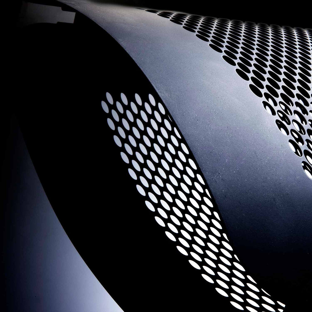 Radiant gas heater grille with perforated panel and dark metal housing, close-up