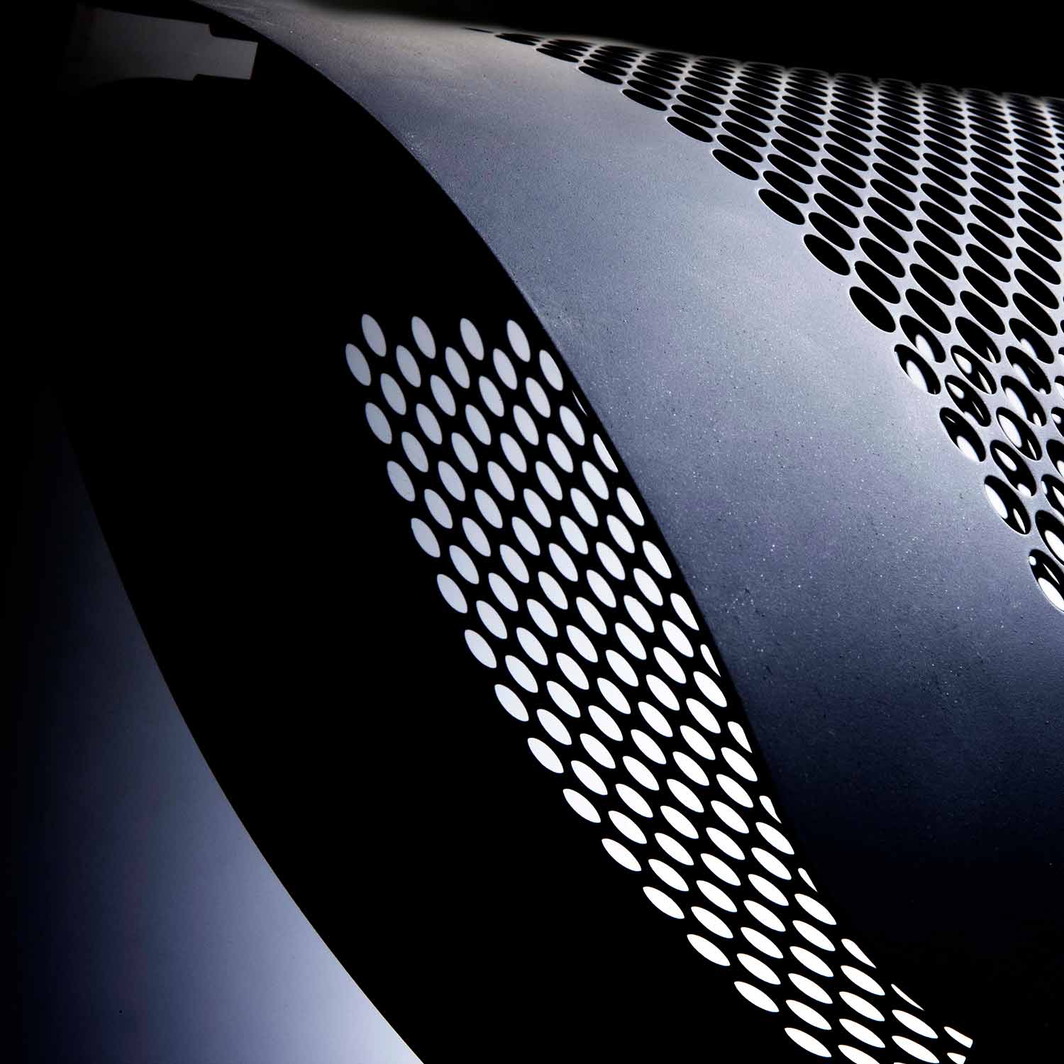 Radiant gas heater grille with perforated panel and dark metal housing, close-up