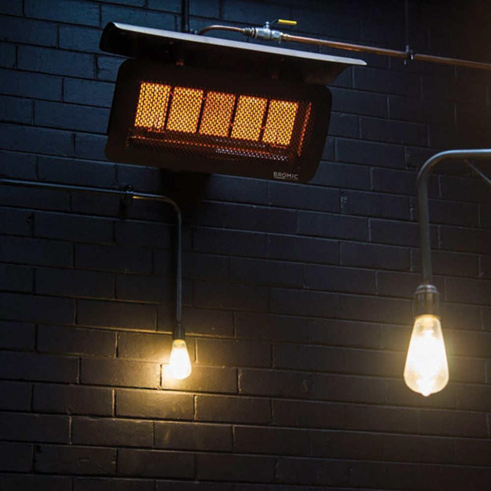 Wall-mounted radiant gas heater with glowing red burner grid, front view