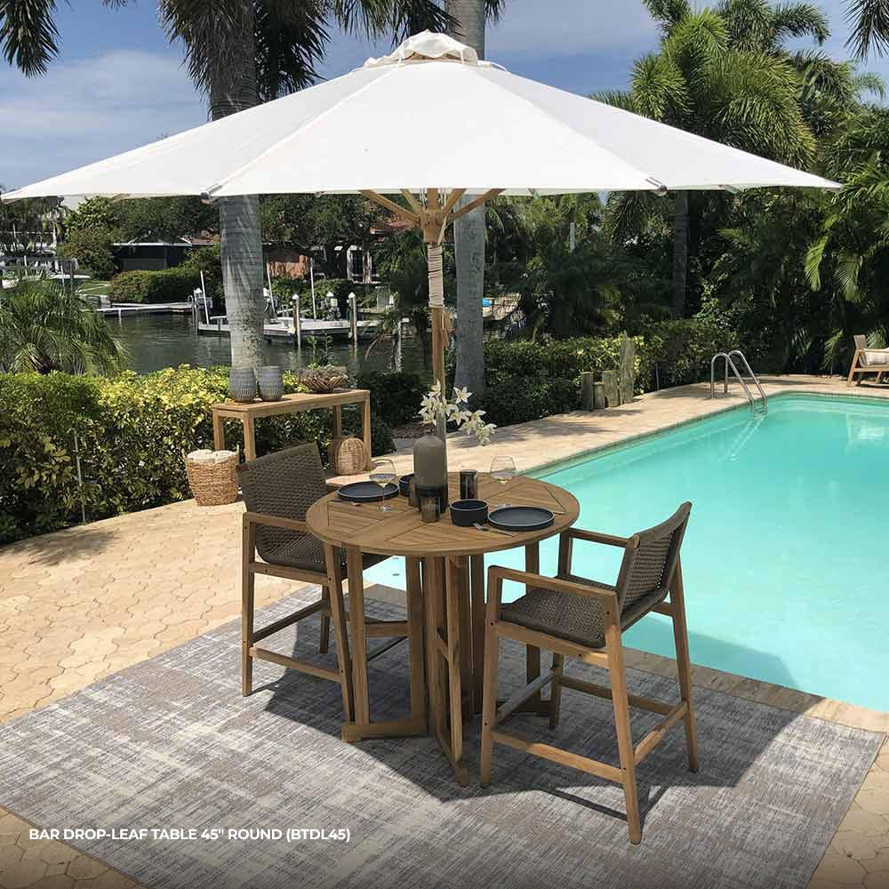 Round teak bar table with slatted drop-leaf top, four legs, and open center supports.