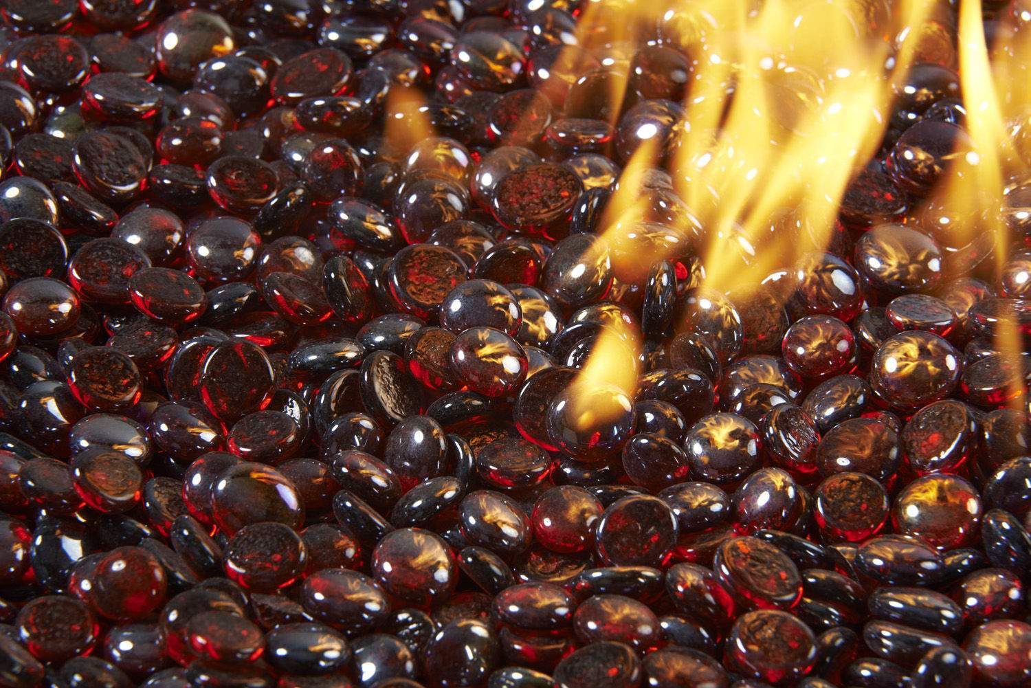Ruby fire glass gems with a stream of glass beads pouring over the pile
