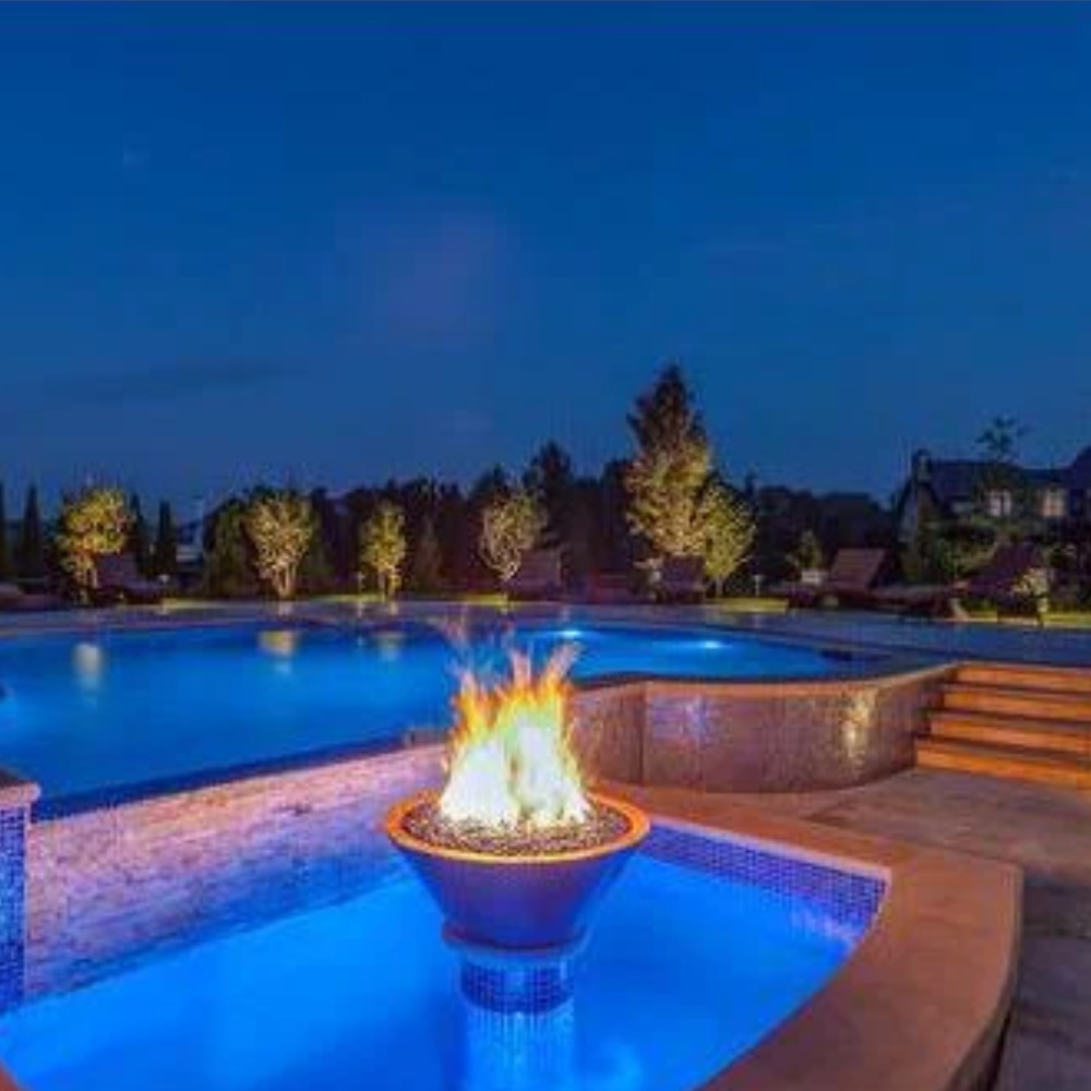 Copper round gas fire bowl with burning flames, set outdoors