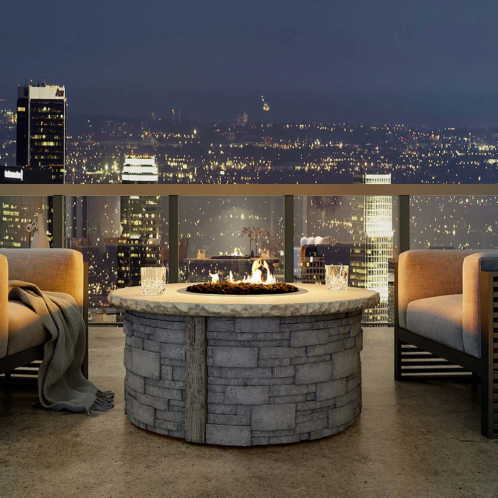 Balcony round gas fire pit with visible flame in a stone fire bowl