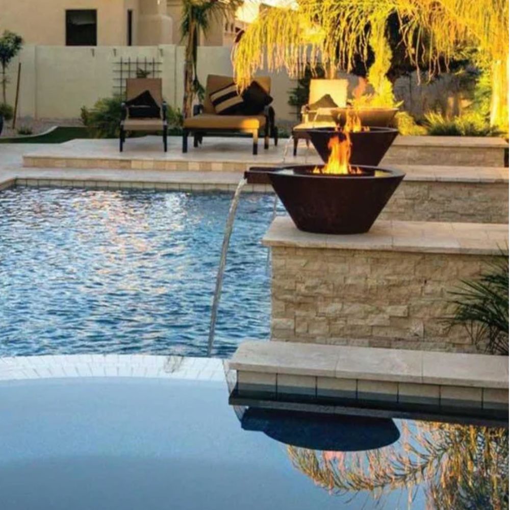 Fire and water bowl with flames beside a swimming pool water stream