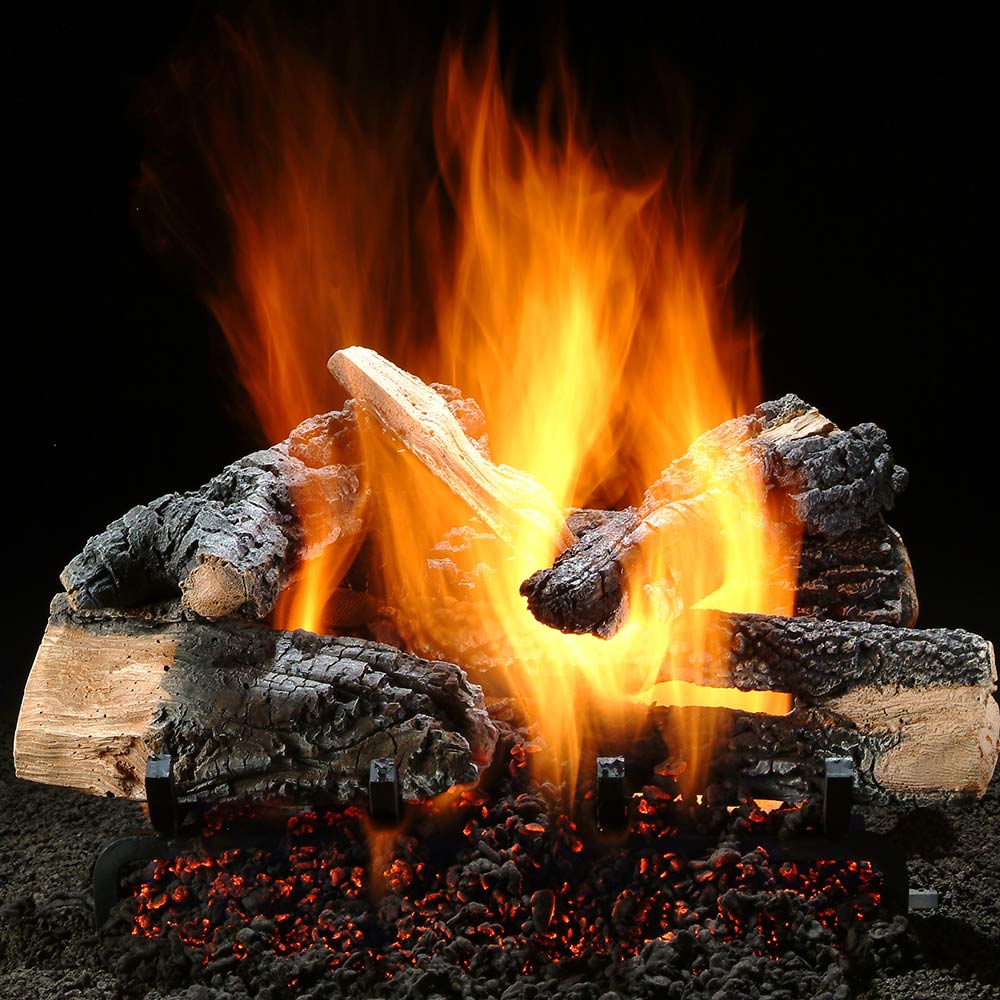 Burning gas logs with split wood, charred rocks, and glowing embers
