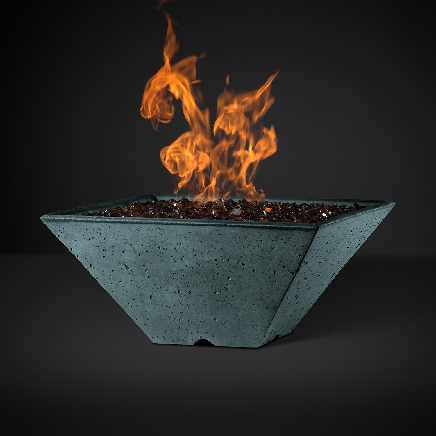 Square fire pit with burning flames, teal speckled bowl and dark rock firebed