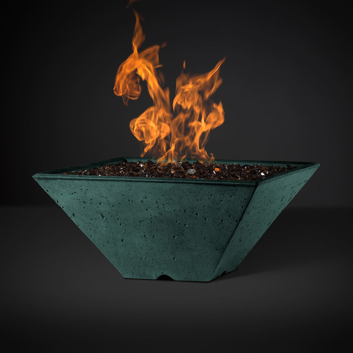 Square fire pit with orange flames and dark lava rocks in a teal basin