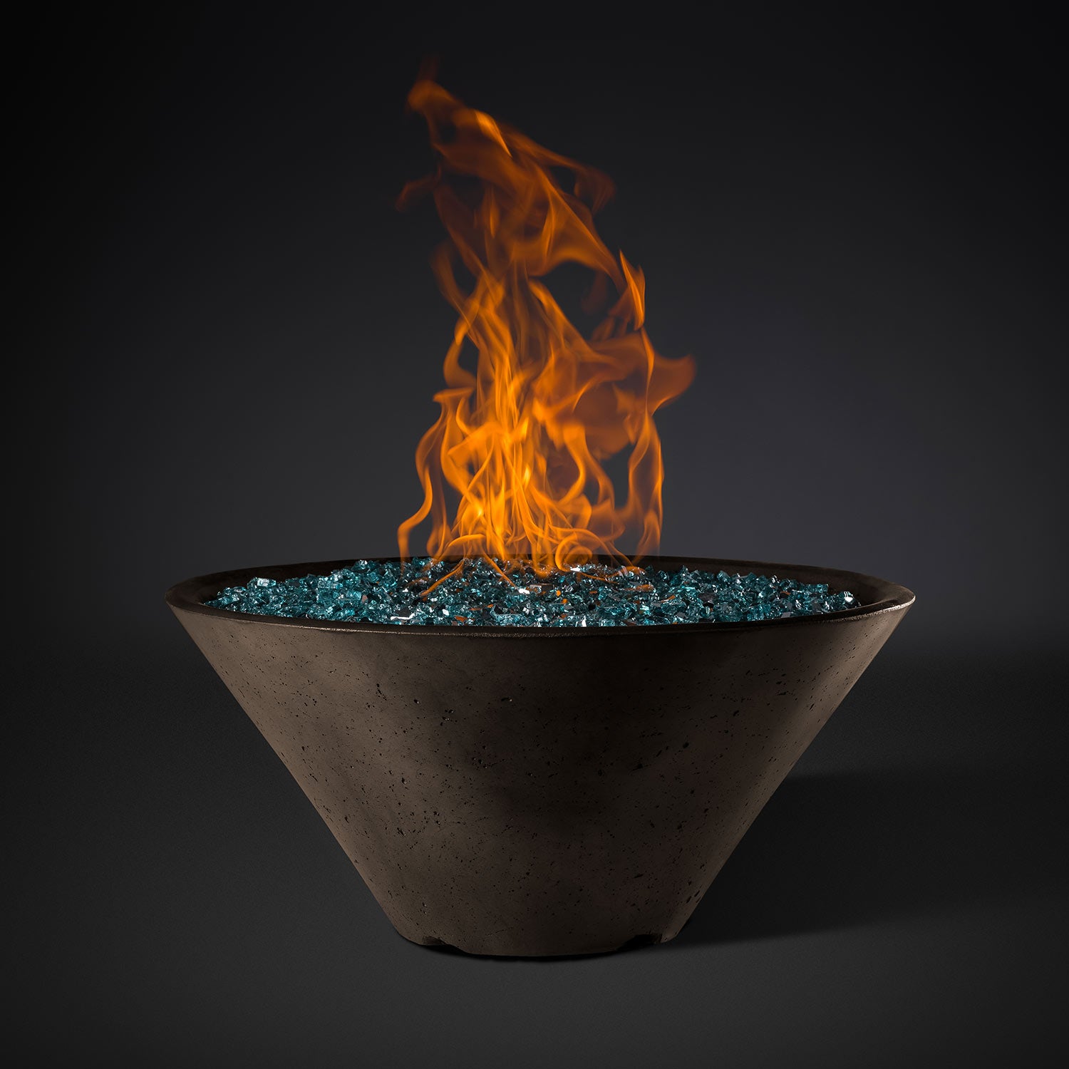 Brown round metal fire pit bowl with blue stone bed and tall orange flames