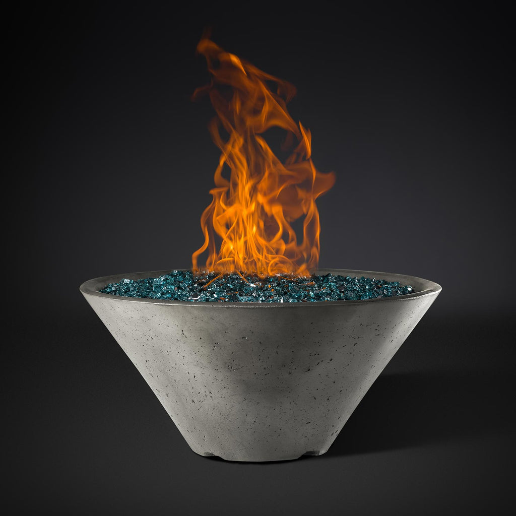 Light gray round metal fire pit bowl with blue stone bed and orange flames
