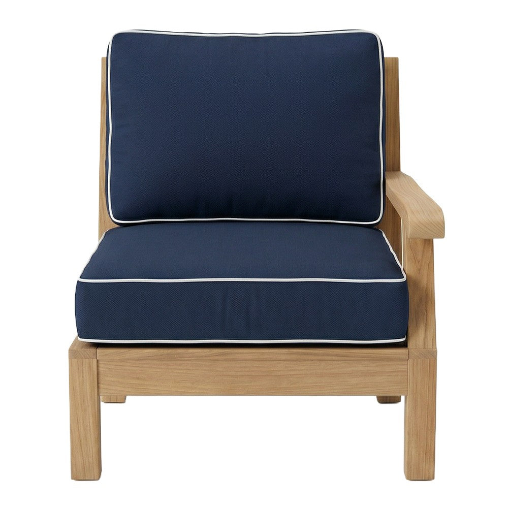 Teak outdoor armchair with navy cushions and light trim, right arm facing.