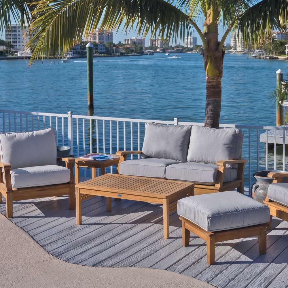 Teak outdoor ottoman with light gray cushion and square seat with wooden legs