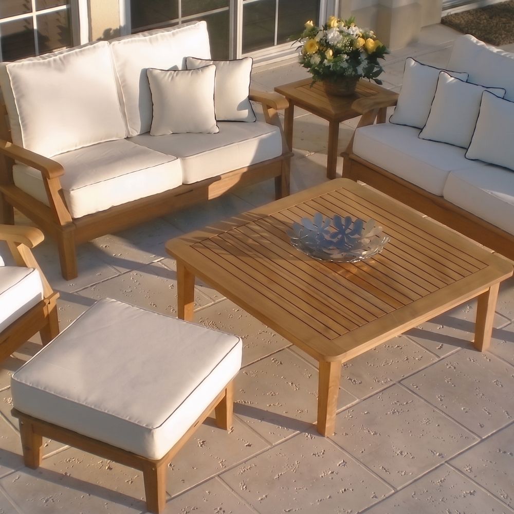 Teak outdoor ottoman with light gray cushion and square padded seat