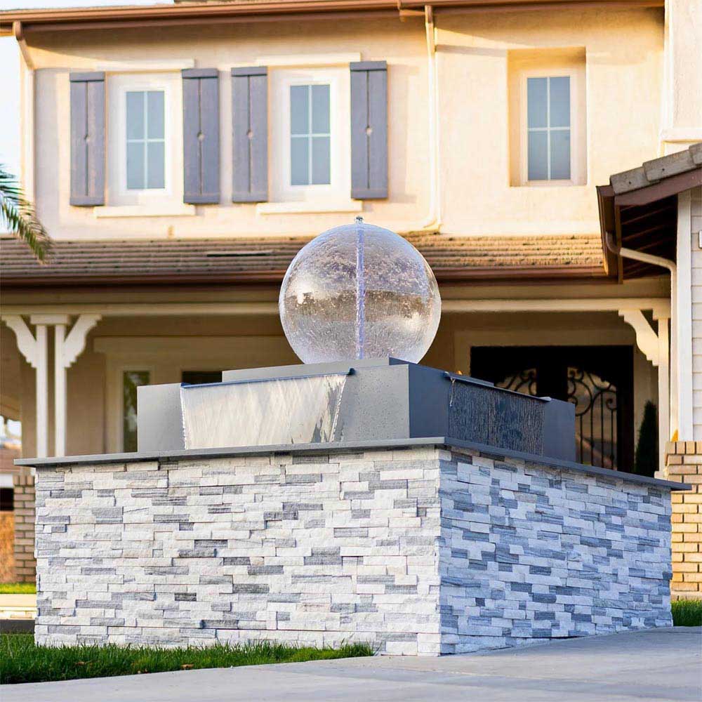 Outdoor square fire and water bowl with gray stone-look panels and silver sphere top