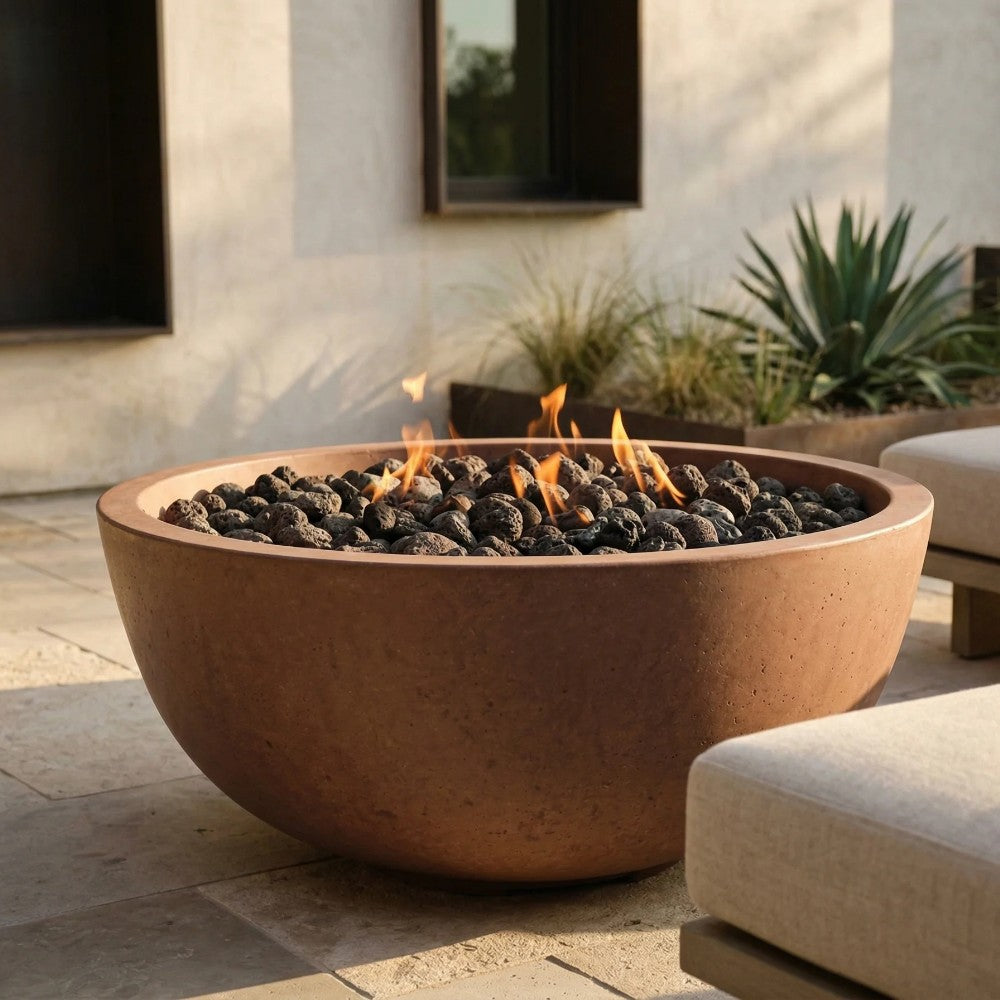 Brown concrete gas fire pit bowl with lit flames and black lava rocks