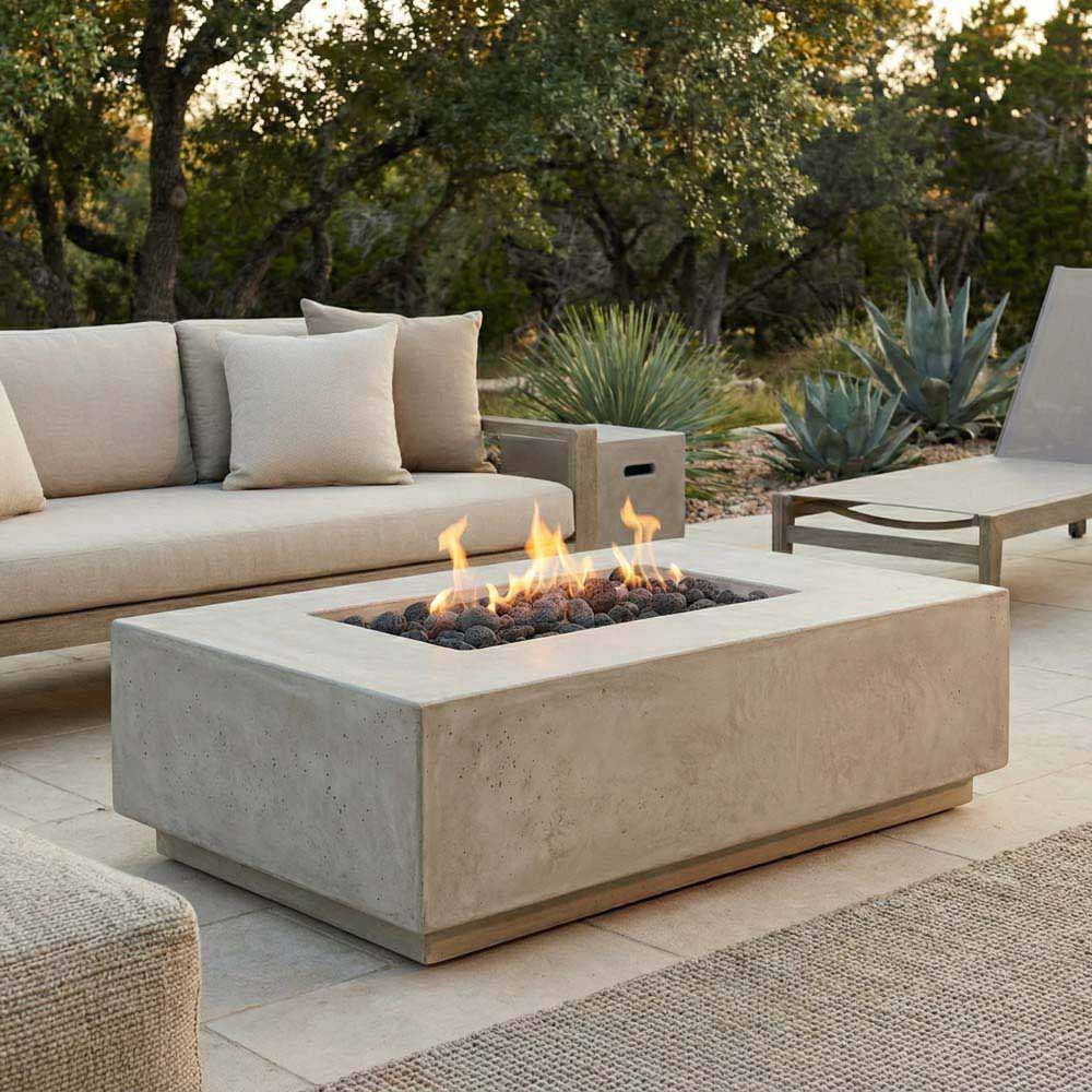 Light gray concrete gas fire pit with flames and black lava rocks