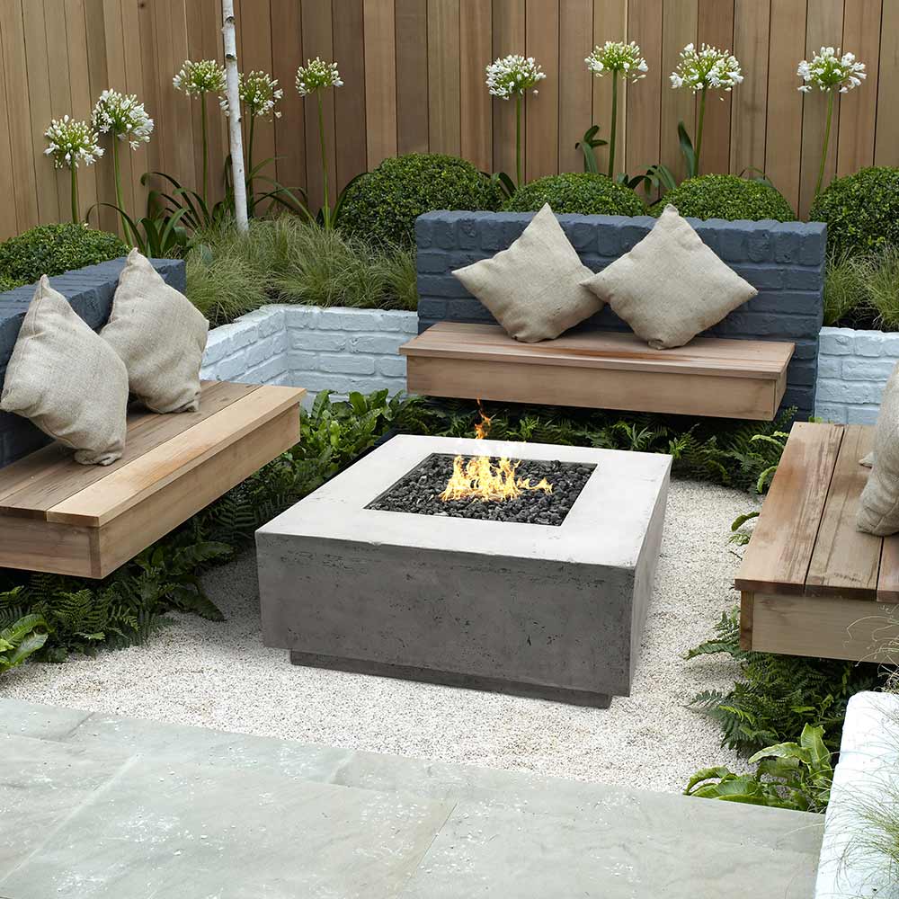 Concrete gas fire pit with square burner showing flames, outdoor patio style