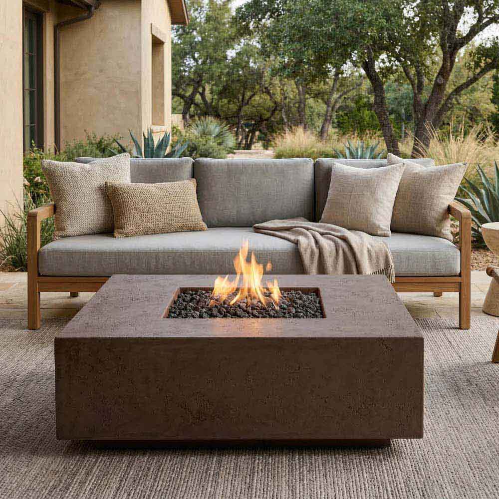 Brown-toned concrete gas fire pit with square flame opening and pebble bed