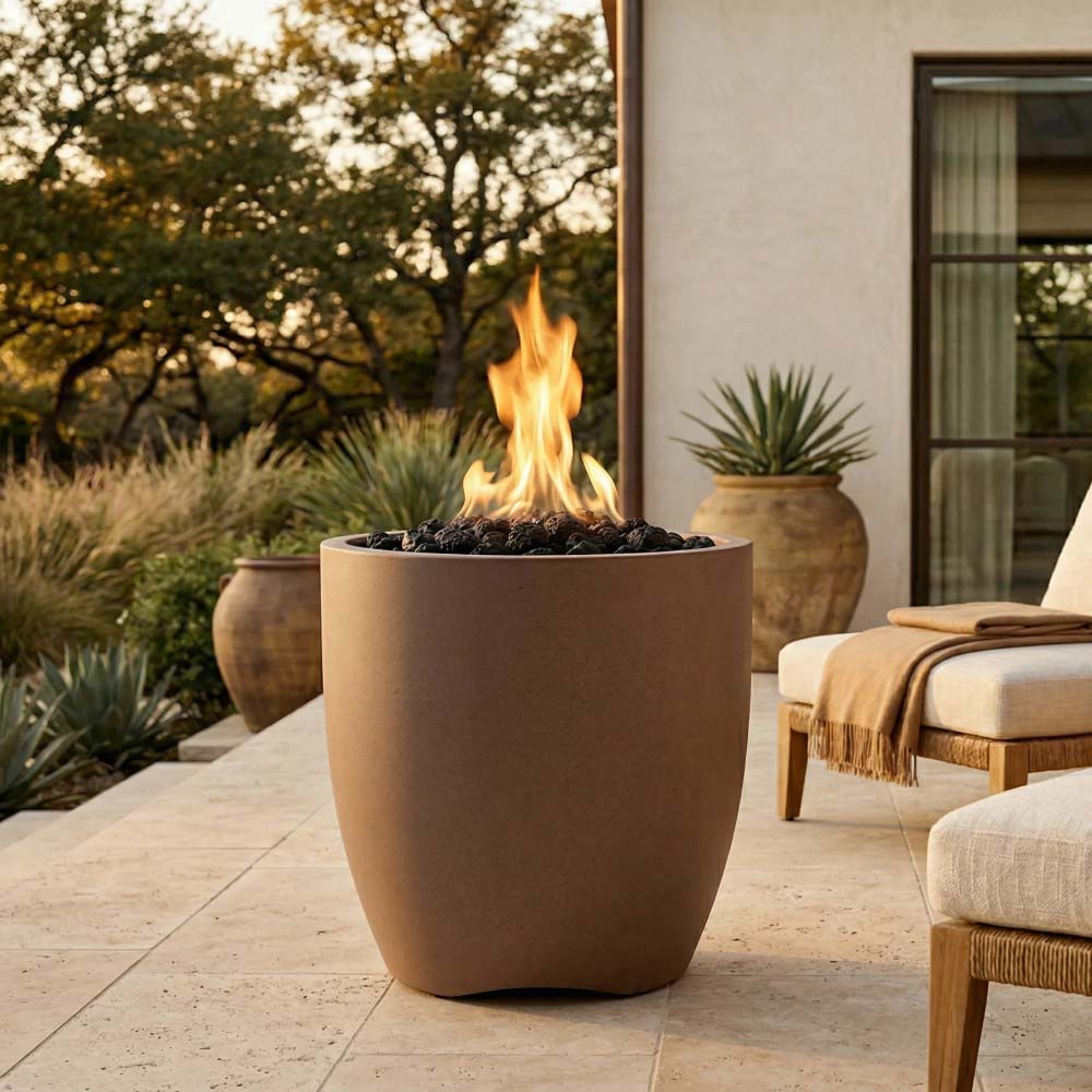Beige-brown concrete gas fire pit bowl with visible flames and black fire media