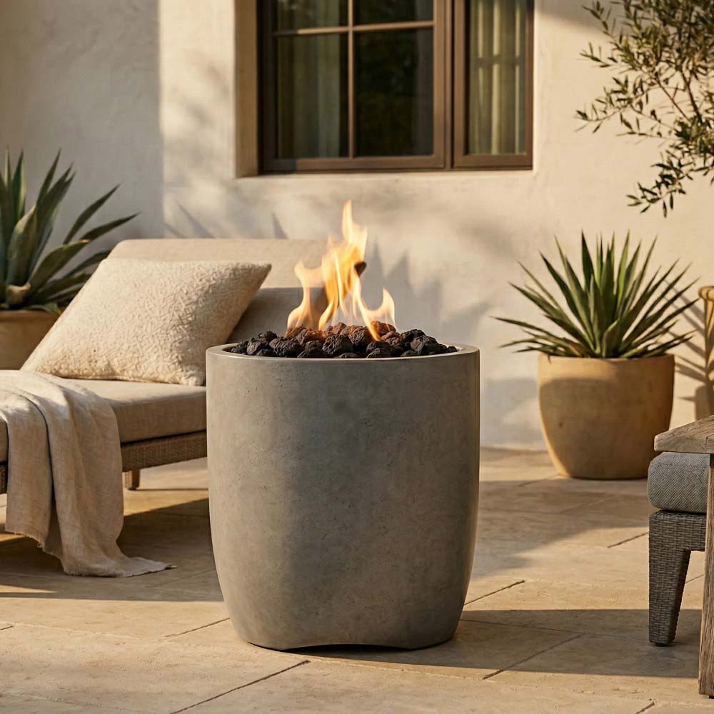 Beige concrete gas fire pit bowl with flames over black fire media