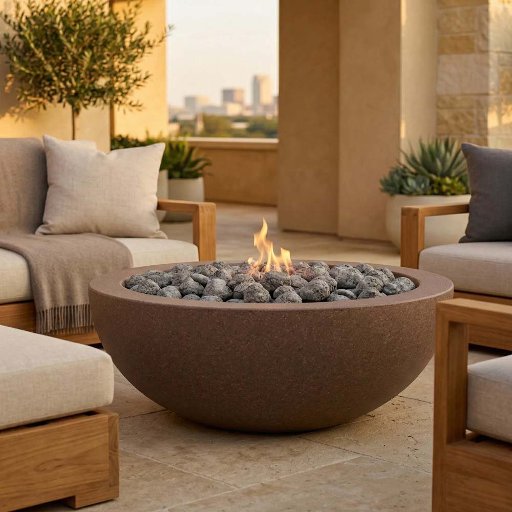 Stone-look concrete gas fire pit with flames and dark lava rocks on terrace
