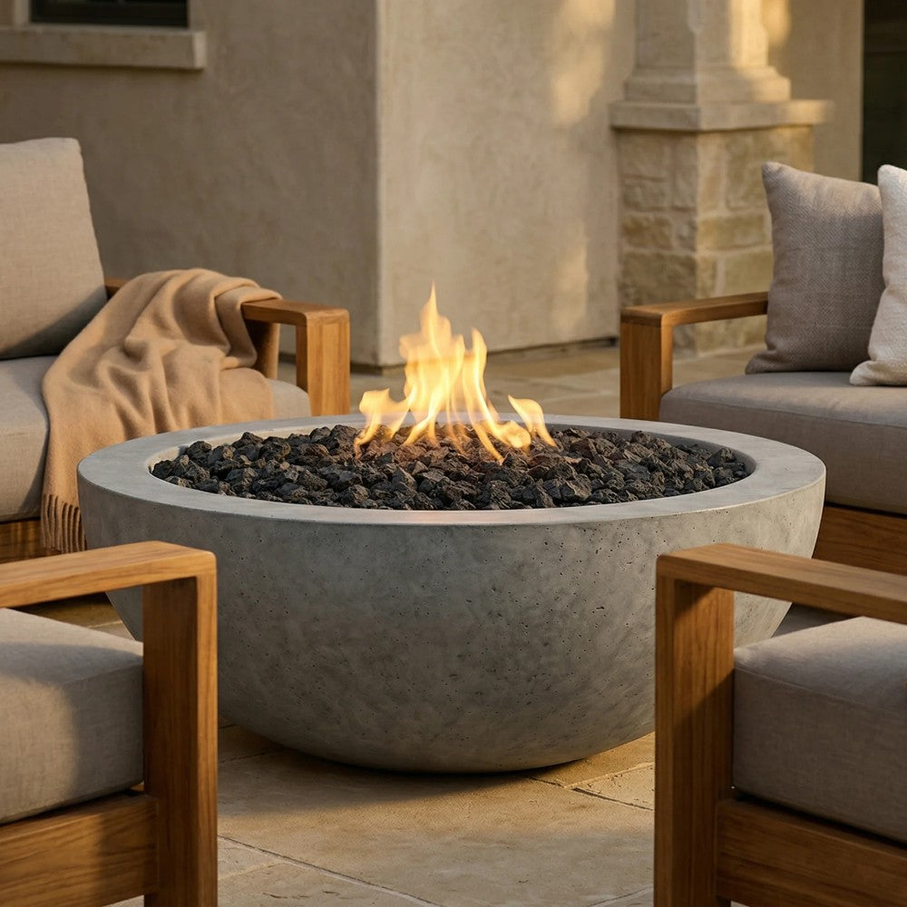 Concrete gas fire pit with tall flames, dark fire media, and round bowl