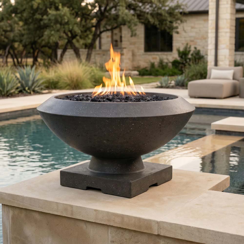 Concrete gas fire bowl with flame and lava rock, set on a stone pool deck