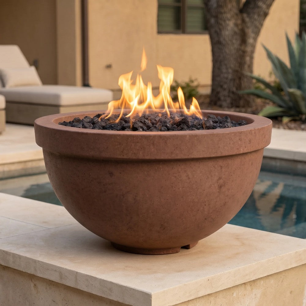 Rust-brown concrete gas fire bowl with burning flames over black lava rocks
