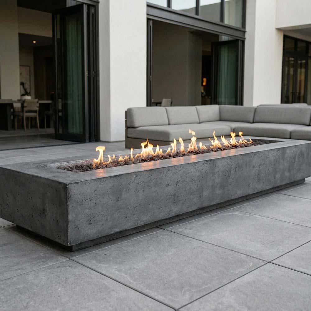 Dark gray concrete gas fire pit with flames burning inside rectangular firebox