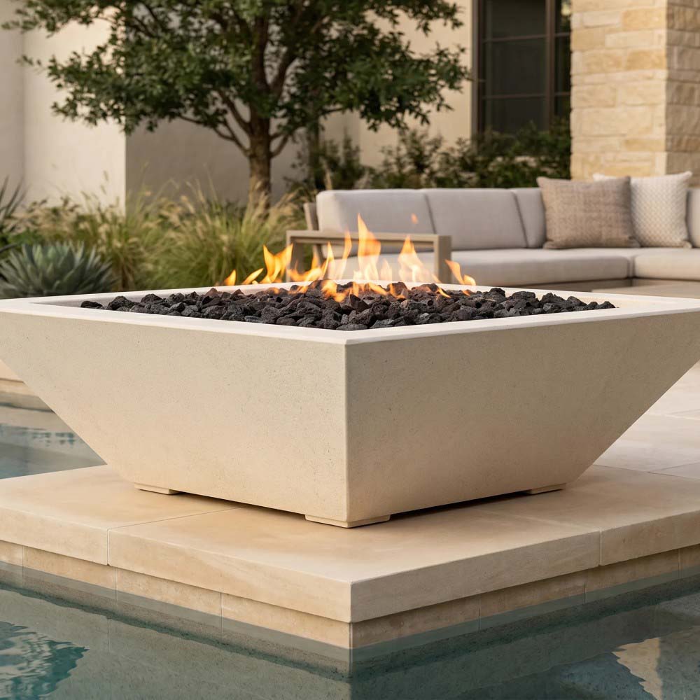 Light concrete gas fire bowl with rectangular shape and burning flames above lava rocks