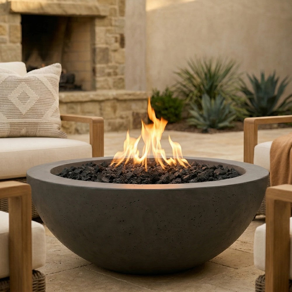 Dark gray concrete gas fire bowl with visible flames over black lava rocks