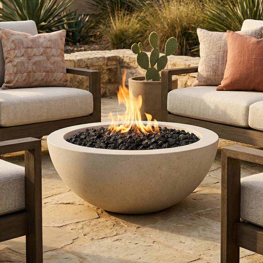 Light concrete gas fire bowl with flames burning over black lava rocks