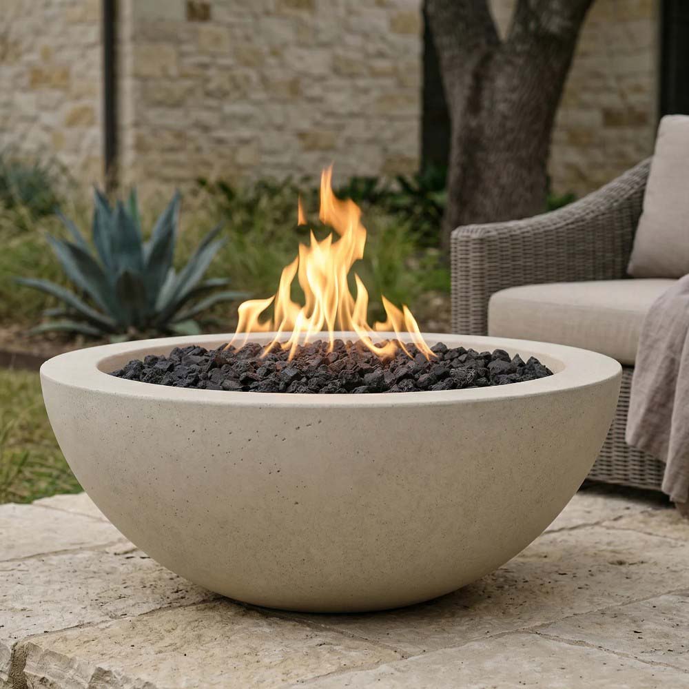 Beige concrete gas fire bowl with flames over black lava rocks