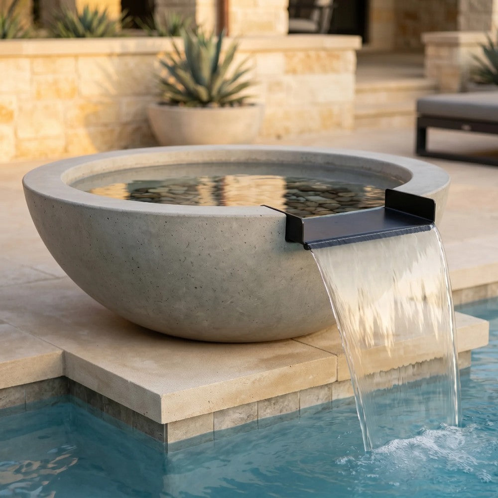 Gray concrete fire and water bowl with spillway water stream, no flame visible