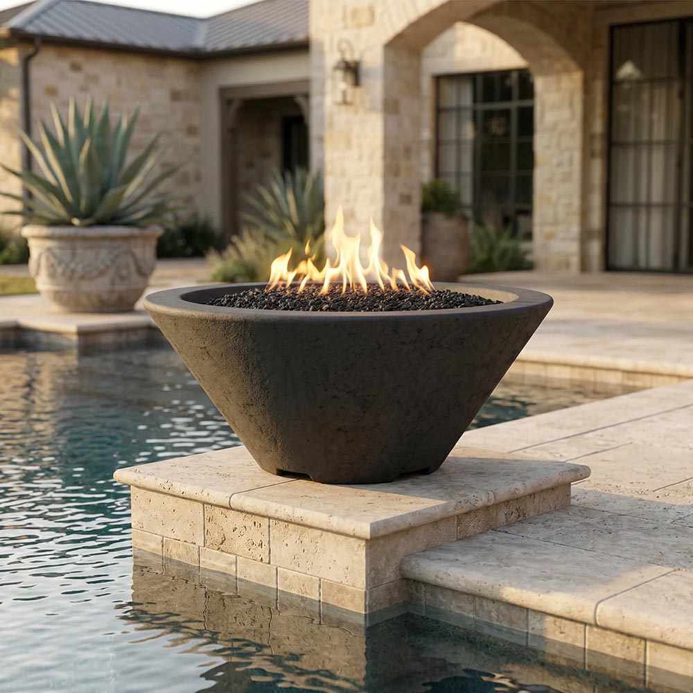 Concrete gas fire bowl on stone pedestal with flames over dark lava rock
