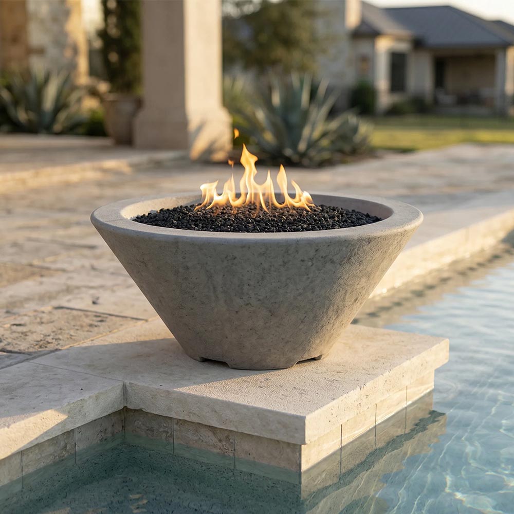 Concrete gas fire bowl on stone pedestal with flames, dark lava rock, gray finish