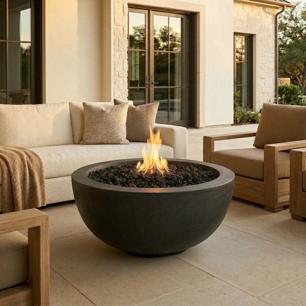 Round concrete gas fire pit with dark gray bowl and visible flames over black burner.
